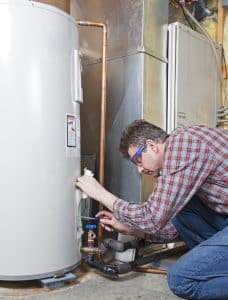 plumber performing maintenance on water heater