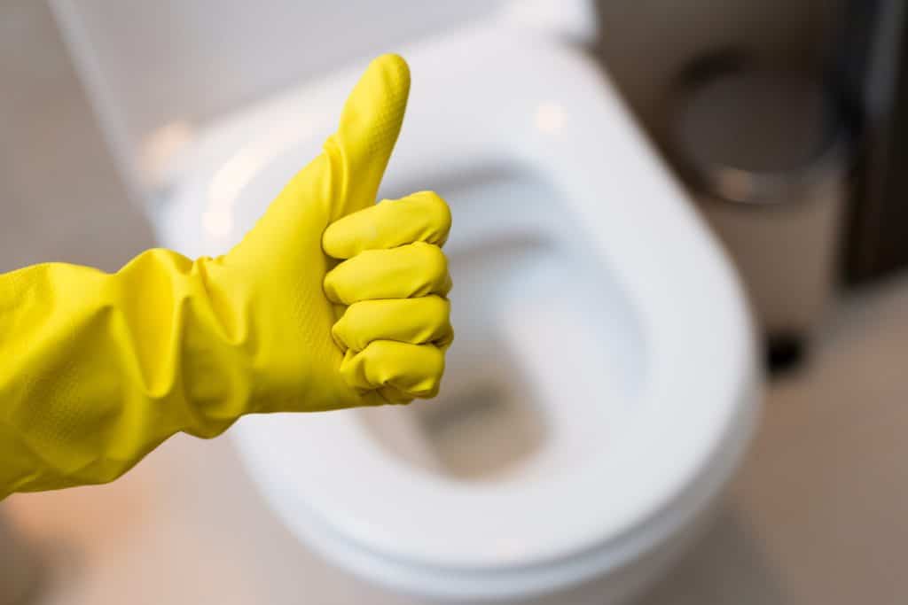thumb up sign against clean toilet